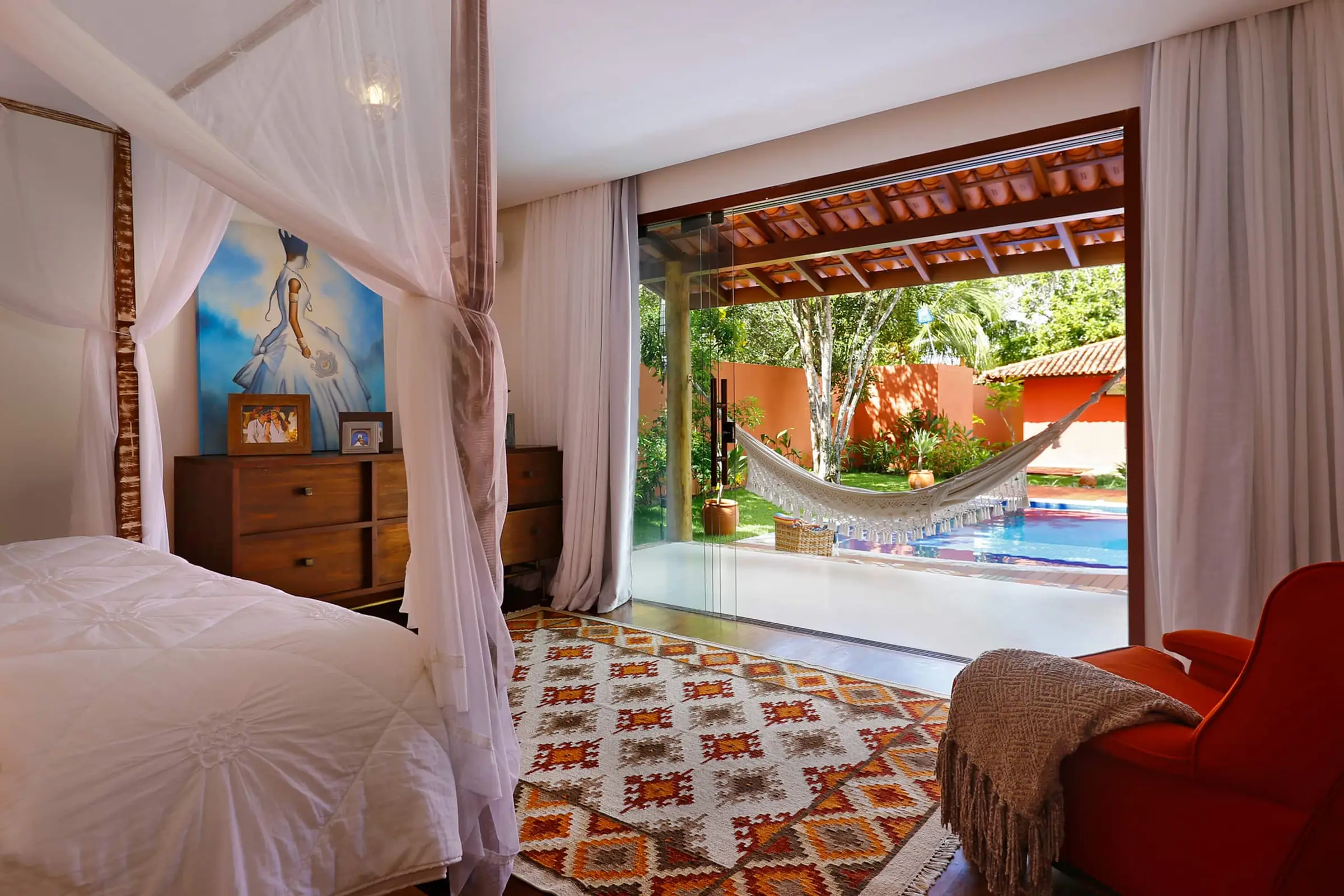 Quarto com vista para a área externa coberta por hammock