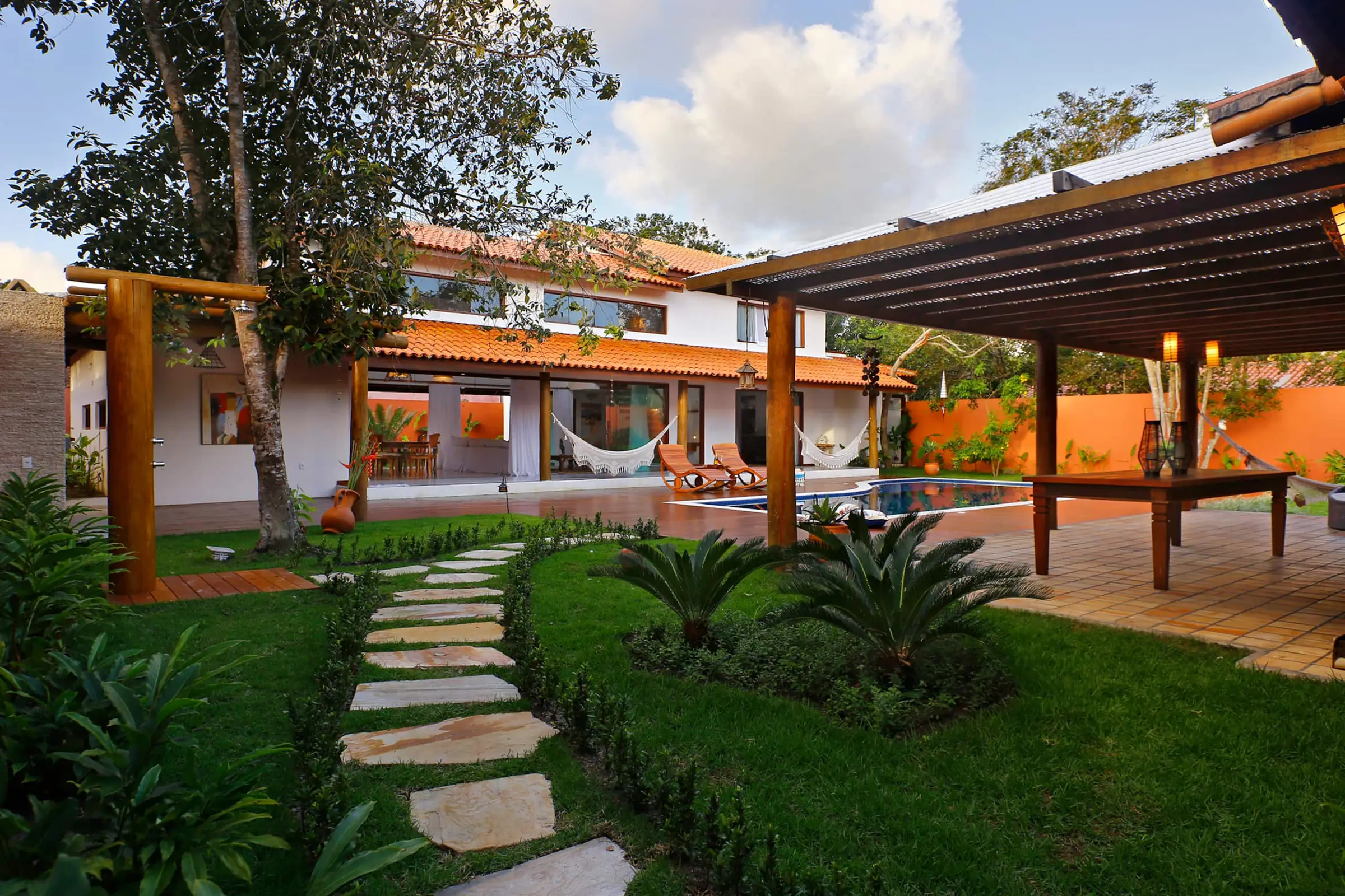 Caminho de pedras entre jardim tropical, ligando as duas casas