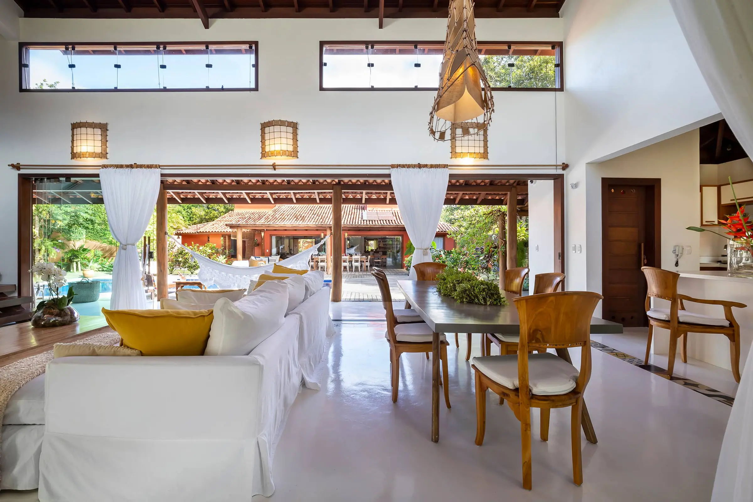 Sala de estar ampla com sofás brancos sob forro de madeira