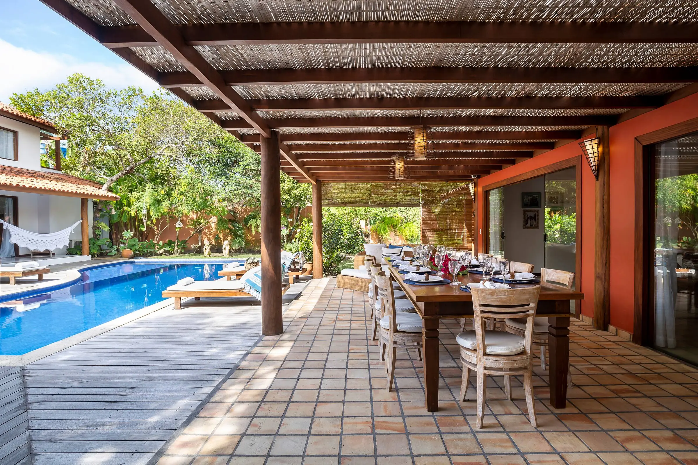 Varanda coberta com mesa de jantar e vista para o jardim